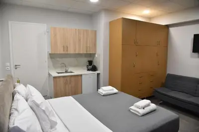 a bedroom with a bed and a couch and a kitchen at Athens Zeus A by Super Host Hub in Athens