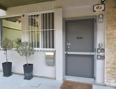 a door to a building with two potted trees in front at Athens Zeus A by Super Host Hub in Athens