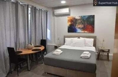 a bedroom with a bed and a desk and a table at Athens Zeus A by Super Host Hub in Athens