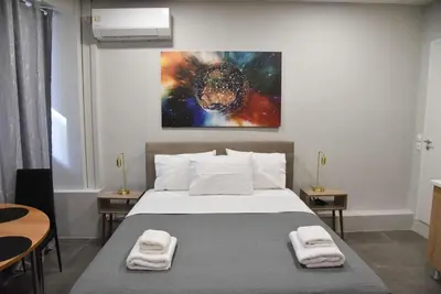 a bedroom with a bed and a painting on the wall at Athens Zeus A by Super Host Hub in Athens