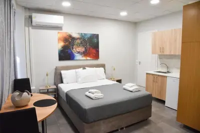 a bedroom with a bed and a table and a kitchen at Athens Zeus A by Super Host Hub in Athens