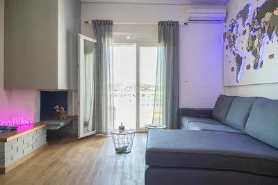 a living room with a blue couch and a fireplace at Sea Front Sophia Porto Rafti in Porto Rafti