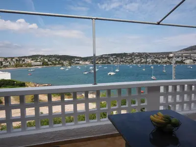 a table with bananas on a balcony with a view of the water at Sea Front Sophia Porto Rafti in Porto Rafti