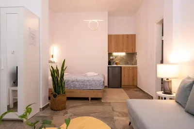 a living room with a bed and a kitchen at Valhalla - Brand New Airport Apt. in Spáta