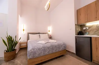 a small bedroom with a bed and a kitchen at Valhalla - Brand New Airport Apt. in Spáta