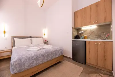 a small bedroom with a bed and a kitchen at Valhalla - Brand New Airport Apt. in Spáta