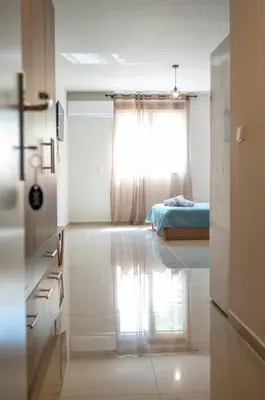 a white room with a bed and a window at Anesis Airport rooms 306 in Koropíon