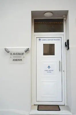 a white garage door with a sign on it at Anesis Airport rooms 306 in Koropíon