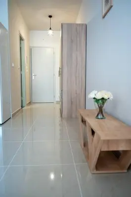 a hallway with a table and a vase of flowers at Anesis Airport rooms 306 in Koropíon