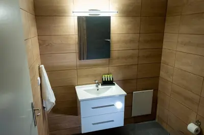 a bathroom with a white sink and a mirror at Anesis Airport rooms 306 in Koropíon
