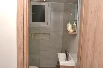 a bathroom with a shower and a white sink at Διαμέρισμα δίπλα από την θάλασσα in Athens