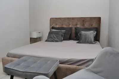 a bedroom with a large bed and a chair at Διαμέρισμα δίπλα από την θάλασσα in Athens