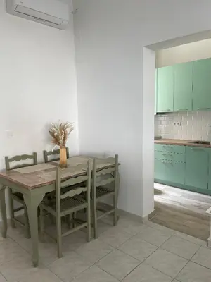 a dining room with a table and chairs and a kitchen at Piraiki Coastal Accommodation in Piraeus
