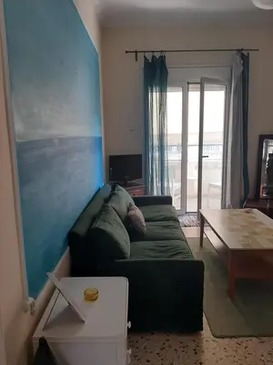 a living room with a green couch and a table at Retro comfy home near Monastiraki in Athens
