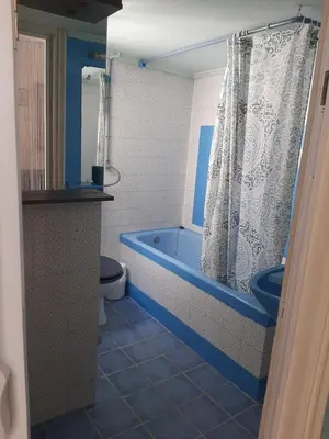 a bathroom with a blue tub and a toilet at Retro comfy home near Monastiraki in Athens