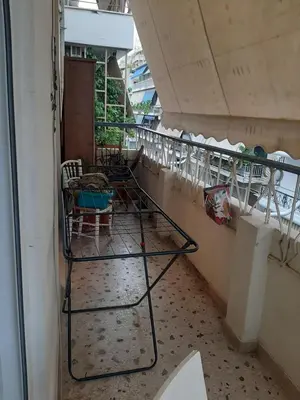 a room with chairs and tables on a balcony at Retro comfy home near Monastiraki in Athens
