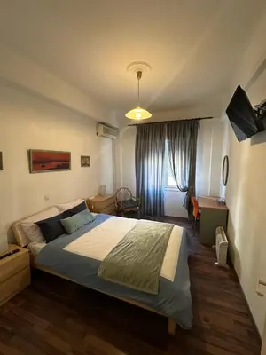 a bedroom with a large bed in a room at Διαμερίσμα με 1 κρεβατοκάμαρα και ένα σαλόνι in Athens