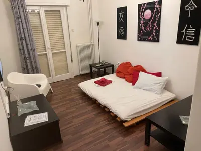 a room with a bed with red pillows on it at Διαμερίσμα με 1 κρεβατοκάμαρα και ένα σαλόνι in Athens