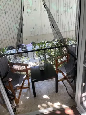 a table and two chairs on a balcony with a coffee cup at Διαμερίσμα με 1 κρεβατοκάμαρα και ένα σαλόνι in Athens
