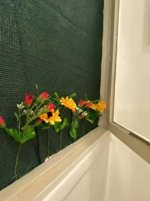a window with a bunch of flowers on a window sill at Διαμερίσμα με 1 κρεβατοκάμαρα και ένα σαλόνι in Athens