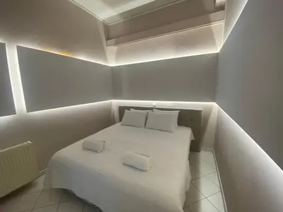 a small room with a white bed with two pillows at Comfortable Apartment Near to Metro in Athens