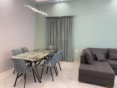 a dining room with a table and a couch at Comfortable Apartment Near to Metro in Athens