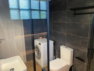 a bathroom with a toilet and a sink and a washing machine at Comfortable Apartment Near to Metro in Athens