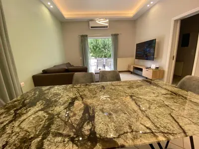 a living room with a large marble table with chairs at Comfortable Apartment Near to Metro in Athens