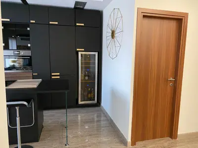 a kitchen with black cabinets and a wooden door at Exzellent ApartAthens 120qm, near Metro M2 in Athens