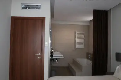 a bathroom with a bed and a sink and a toilet at Exzellent ApartAthens 120qm, near Metro M2 in Athens