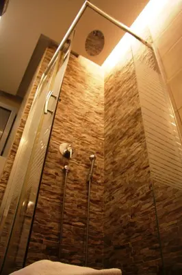 a bathroom with a shower with a stone wall at X Dream Hotel-Adults Only in Athens