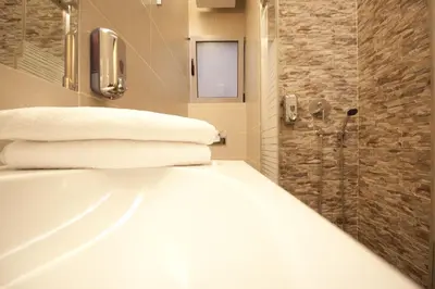a bathroom with a tub and a shower with towels at X Dream Hotel-Adults Only in Athens