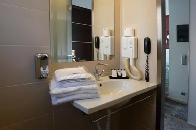 a bathroom with a sink with a phone and towels at X Dream Hotel-Adults Only in Athens