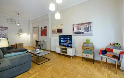 a living room with a couch and a tv at Cosy 2BR flat near Ampelokipoi station & hospitals in Athens
