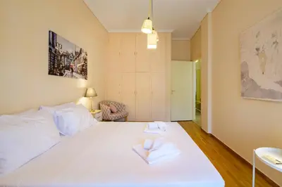 a bedroom with a large white bed with two towels at Cosy 2BR flat near Ampelokipoi station & hospitals in Athens