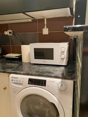 a microwave sitting on top of a washing machine at Glyfada First Center in Athens