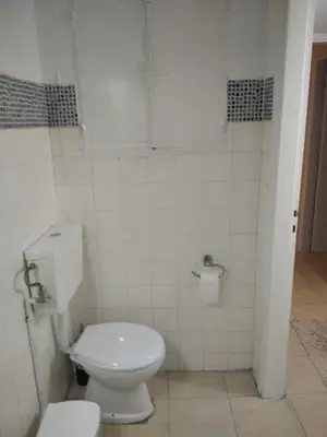 a bathroom with a white toilet in a room at Glyfada First Center in Athens