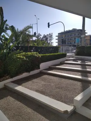a row of concrete steps with bushes and a street light at Glyfada First Center in Athens