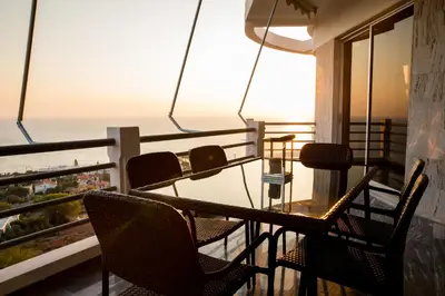 a balcony with chairs and a table and a view of the ocean at Saronicos Gulf View in Anavissos in Anavissos