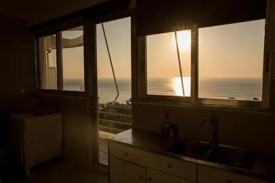 a kitchen with two windows and a view of the ocean at Saronicos Gulf View in Anavissos in Anavissos