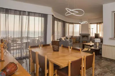 a dining room with a table and a living room at Saronicos Gulf View in Anavissos in Anavissos