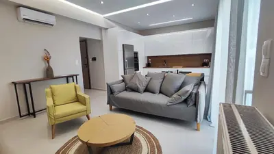 a living room with a couch and a yellow chair at Luxury Apartment Stella in Piraeus