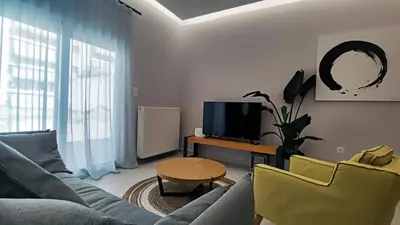 a living room with a couch and a table and a tv at Luxury Apartment Stella in Piraeus