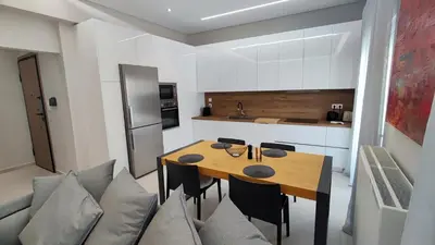 a kitchen and dining room with a wooden table and chairs at Luxury Apartment Stella in Piraeus