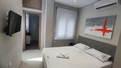 a bedroom with a white bed and a television at Luxury Apartment Stella in Piraeus
