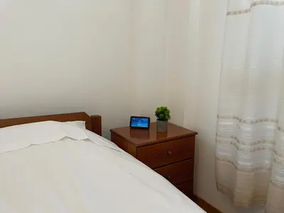 a bedroom with a bed with a laptop on a night stand at Eagles Nest Villa Athenian Riviera in Aghia Marina near Lagonisi, next to the beach close to Athens Airport in Aghia Marina