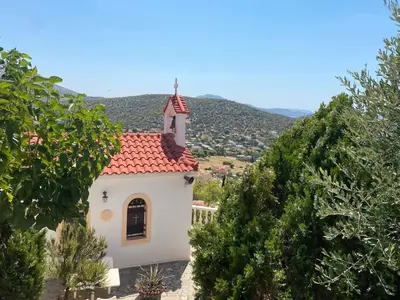 a small white chapel with a red roof at Eagles Nest Villa Athenian Riviera in Aghia Marina near Lagonisi, next to the beach close to Athens Airport in Aghia Marina