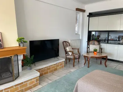 a living room with a fireplace and a television at Eagles Nest Villa Athenian Riviera in Aghia Marina near Lagonisi, next to the beach close to Athens Airport in Aghia Marina