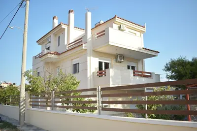 a white house with a fence in front of it at Mountain-to-Sea Oasis in Kalívia Thorikoú