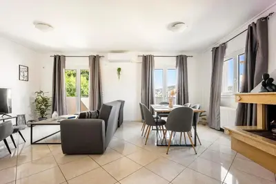 a living room with a table and chairs at Mountain-to-Sea Oasis in Kalívia Thorikoú